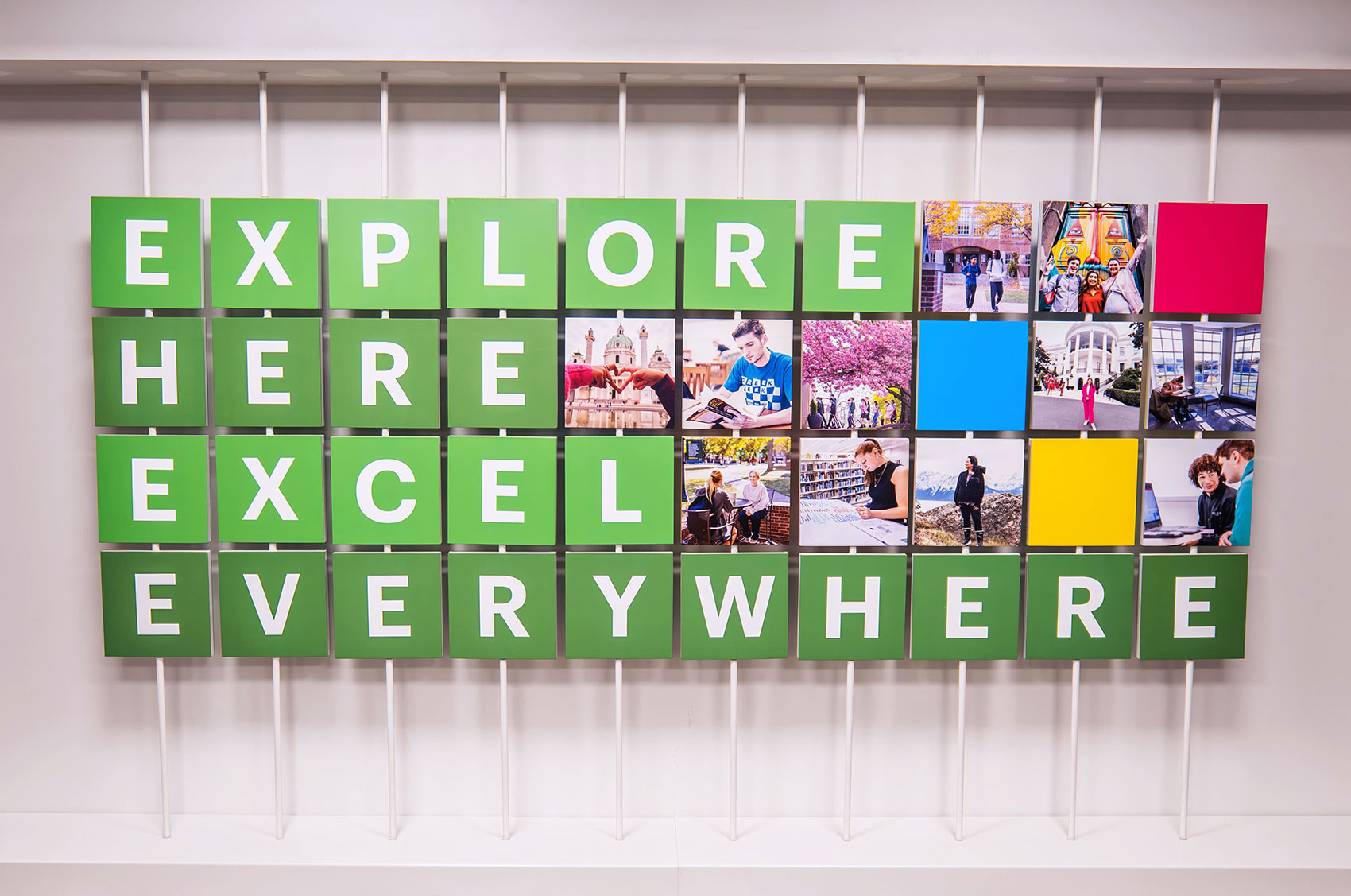 Green sign with the text Explore Here, Excel Everywhere surrounded by diverse, vibrant travel and study photos.