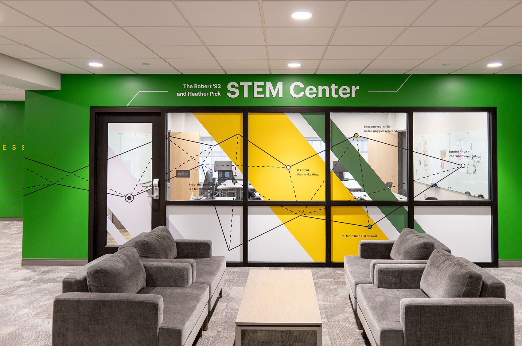 Modern STEM Center with gray couches and vibrant geometric wall graphics, promoting innovation and learning in science and technology.