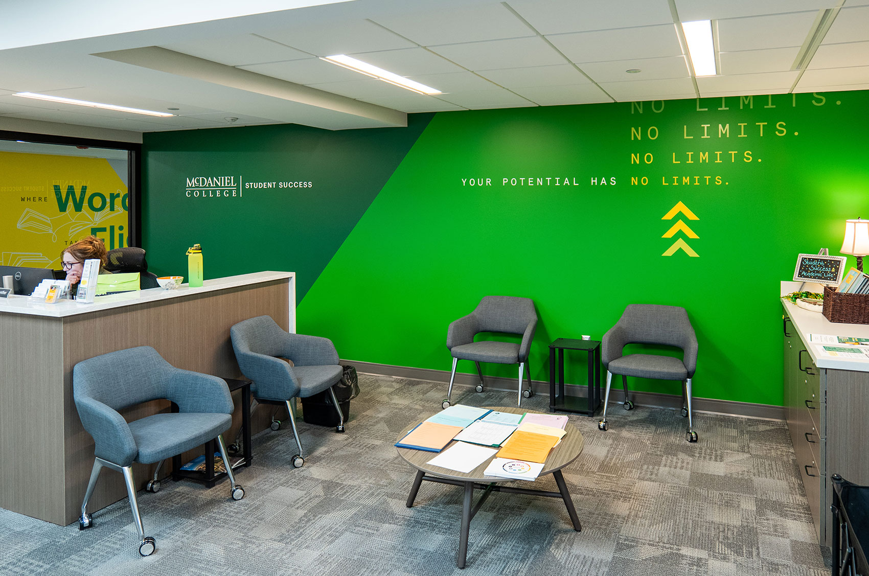 Modern college office with lounge chairs and motivational No Limits wall at McDaniel College Student Success Center.