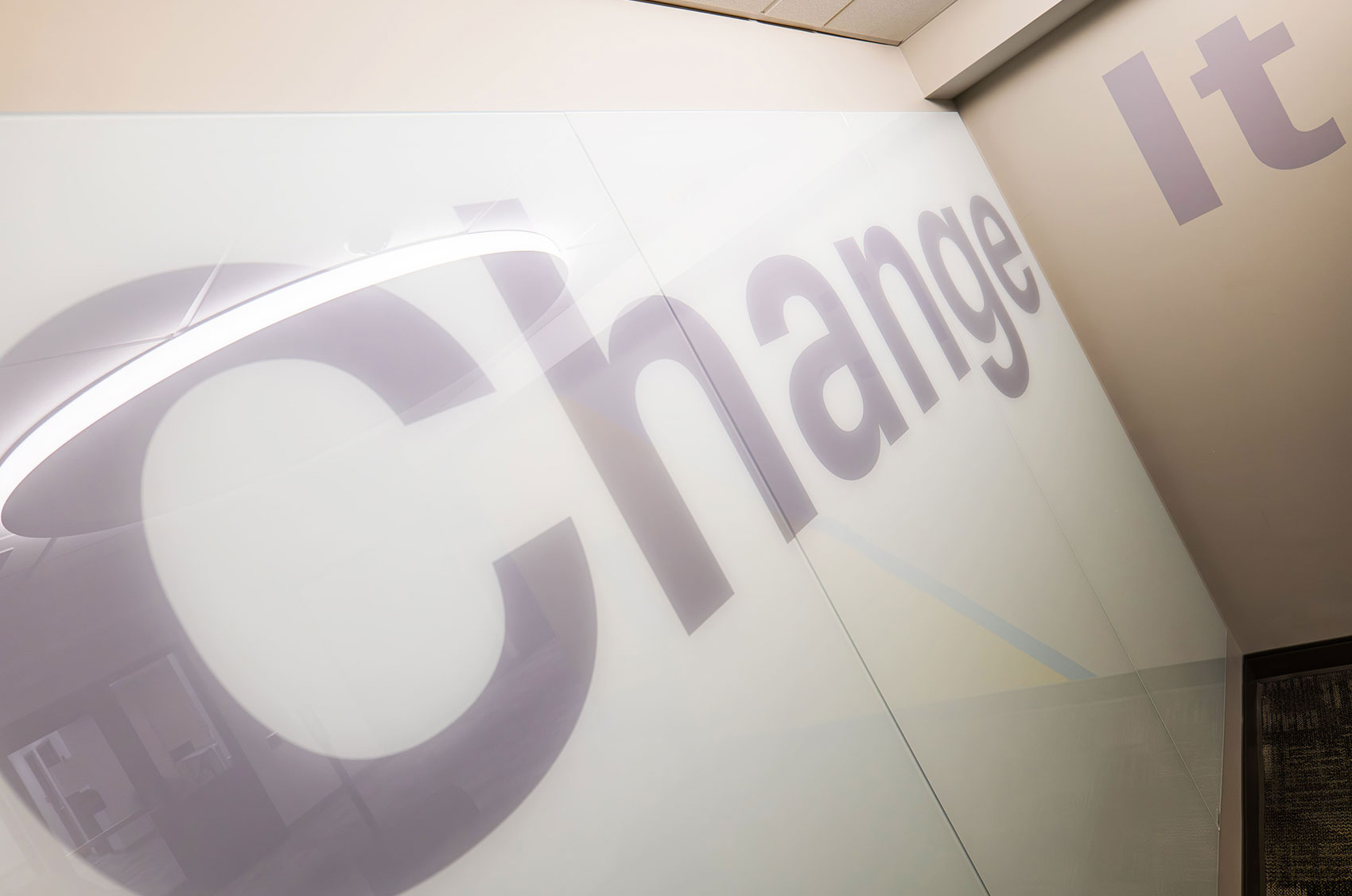 Modern office wall with Change It in oversized text, reflecting a motivation for innovation and transformation.